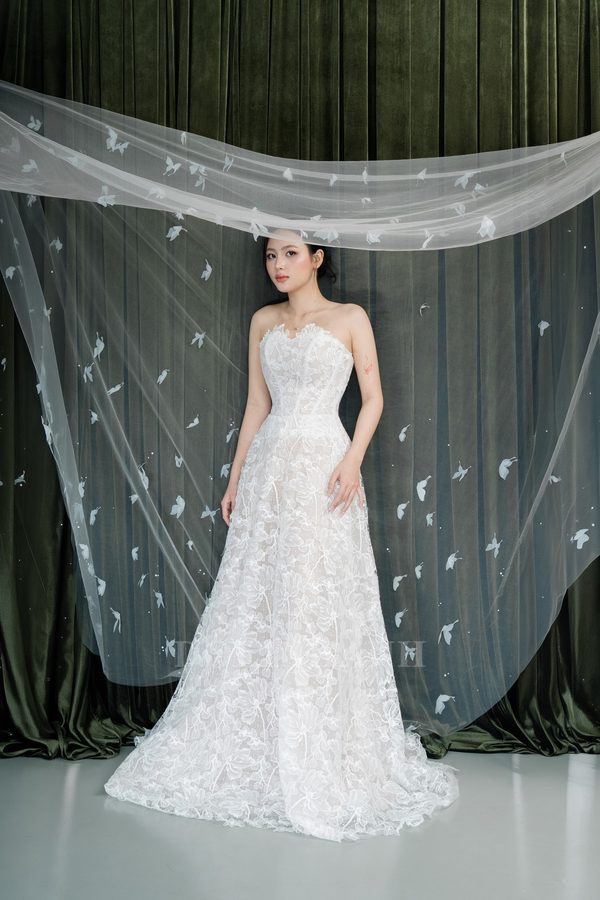 The Ba Be butterfly appliqué veil draped in front of a bride in a lace gown