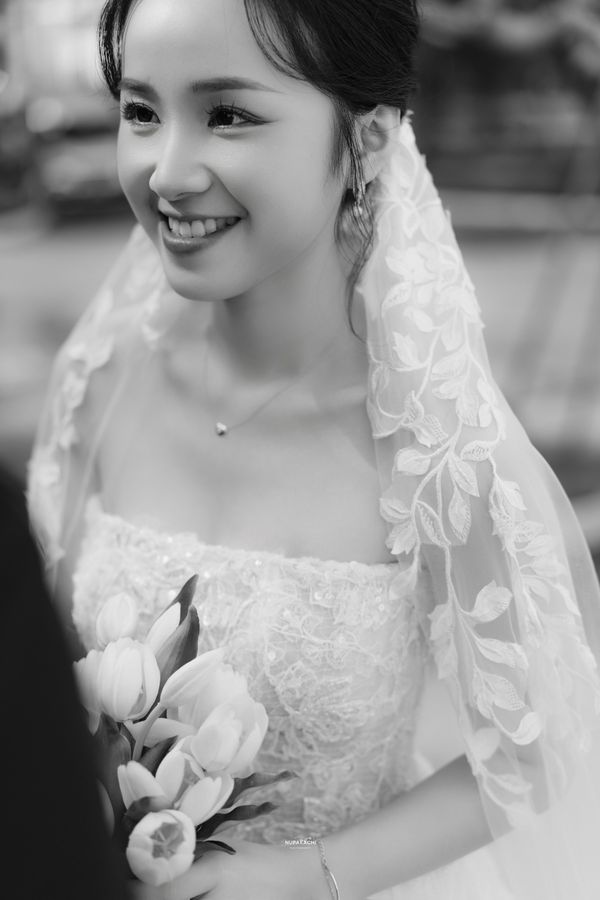 The Cuc Phuong climbing leaf lace cathedral wedding veil on a bride by a brick wall — photo 6