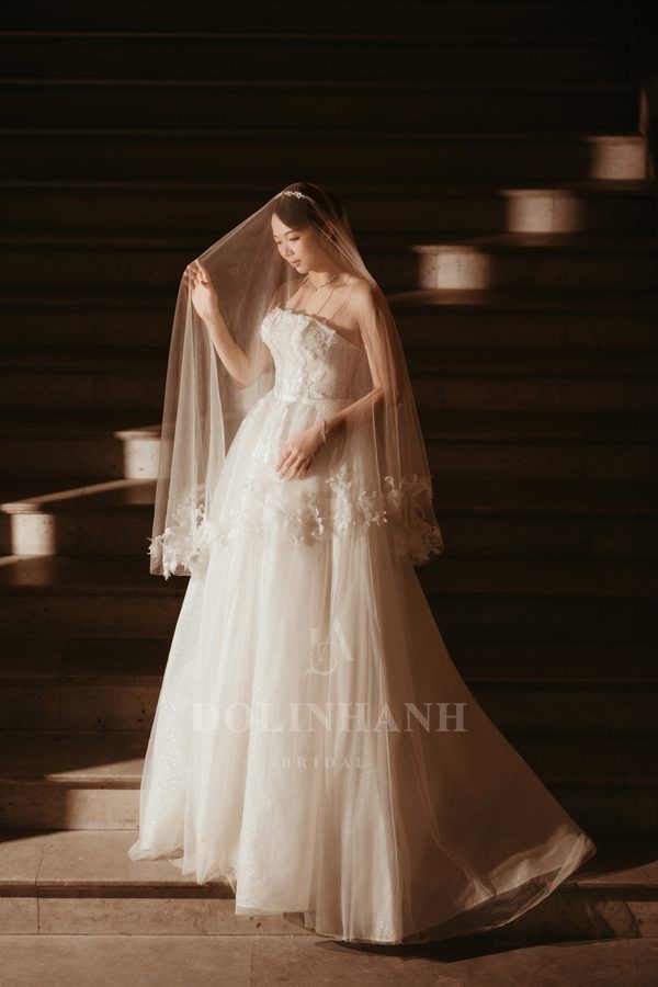 The Quan Lan 3D flower hem veil on a bride under warm light
