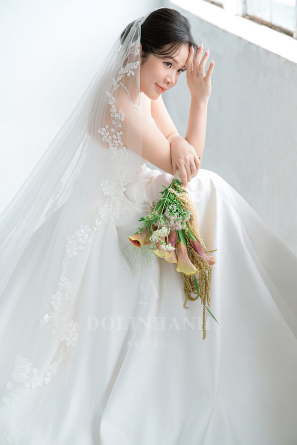 The Ta Xua leaf lace cathedral wedding veil on a seated bride